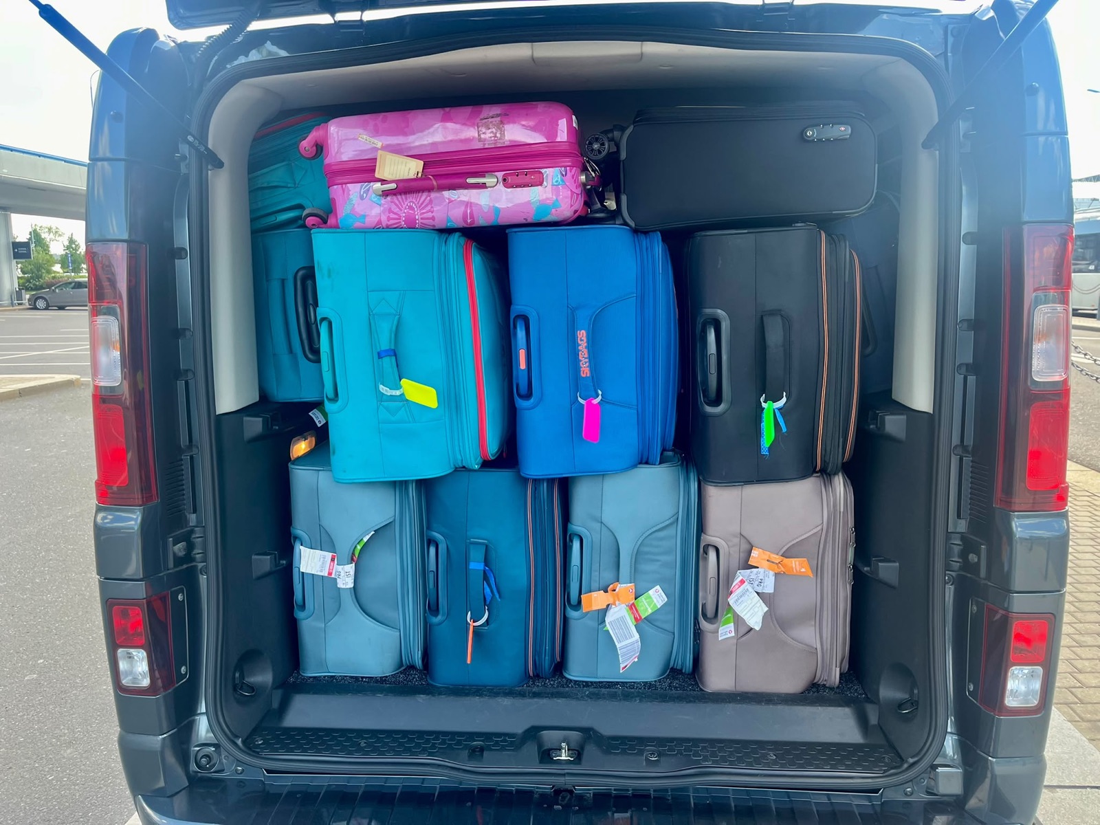 Suitcases loaded in a passenger van for an airport transfer